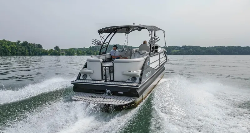 Slide: The Image of 2022 Montara MT 2.0 25 CW boat cruising on a lake with lush green shoreline. - 7