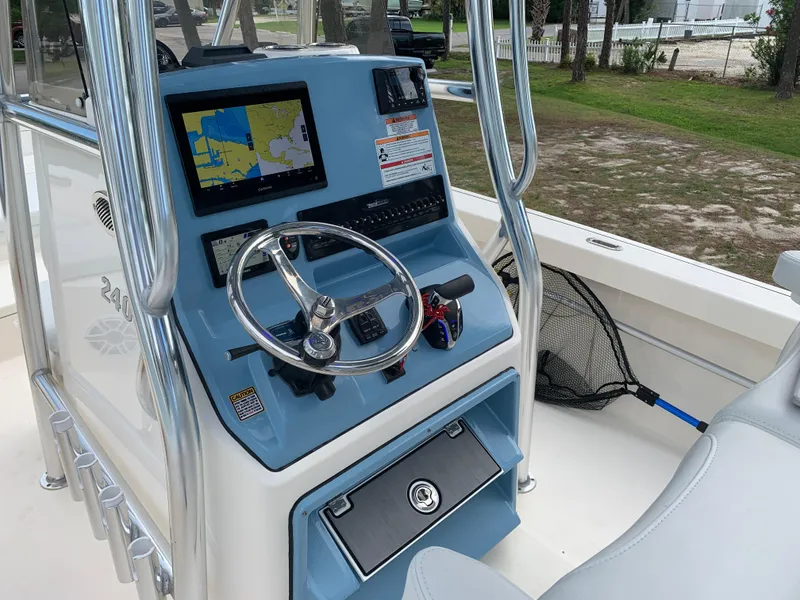 Slide: The Image of 2024 Pathfinder 2400 TRS boat console with steering wheel and navigation display. - 17