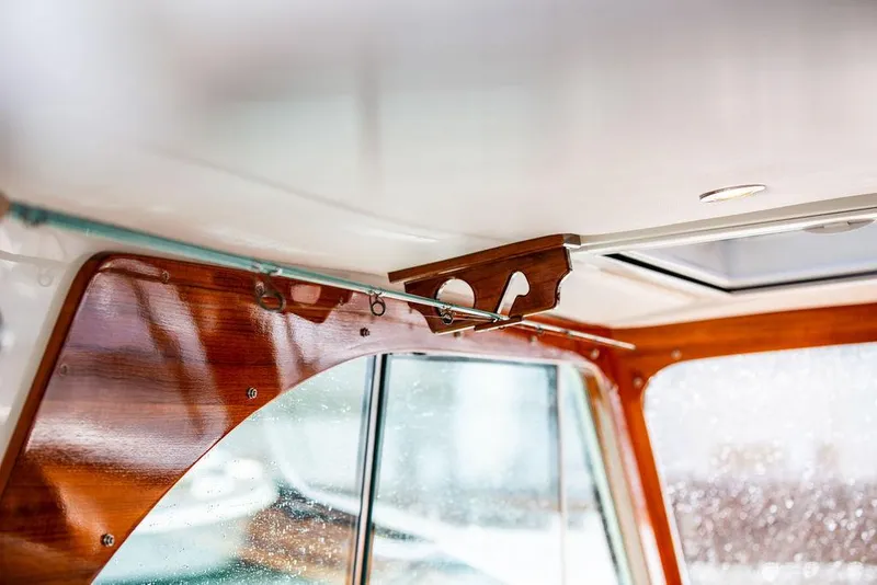 Slide: The Image of Interior detail of 2023 Hinckley Picnic Boat 34 S, showcasing elegant wood finish and window design. - 11
