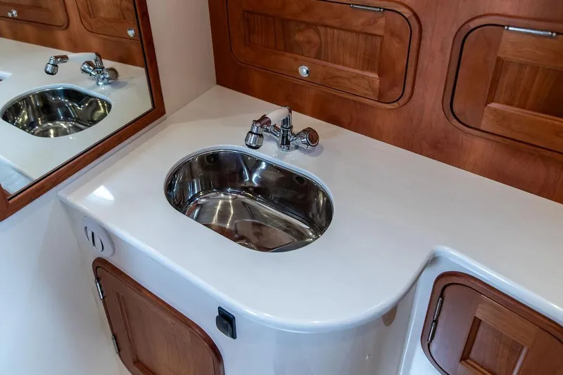 Slide: The Image of 2023 Hinckley Picnic Boat 34 S bathroom with sleek sink and wooden cabinetry. - 16