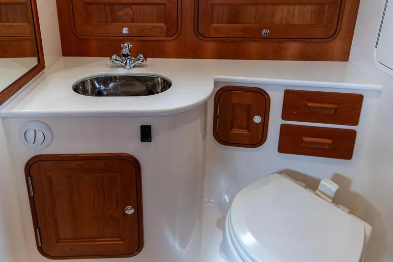 Slide: The Image of 2023 Hinckley Picnic Boat 34 S bathroom with wooden cabinetry and modern fixtures. - 17