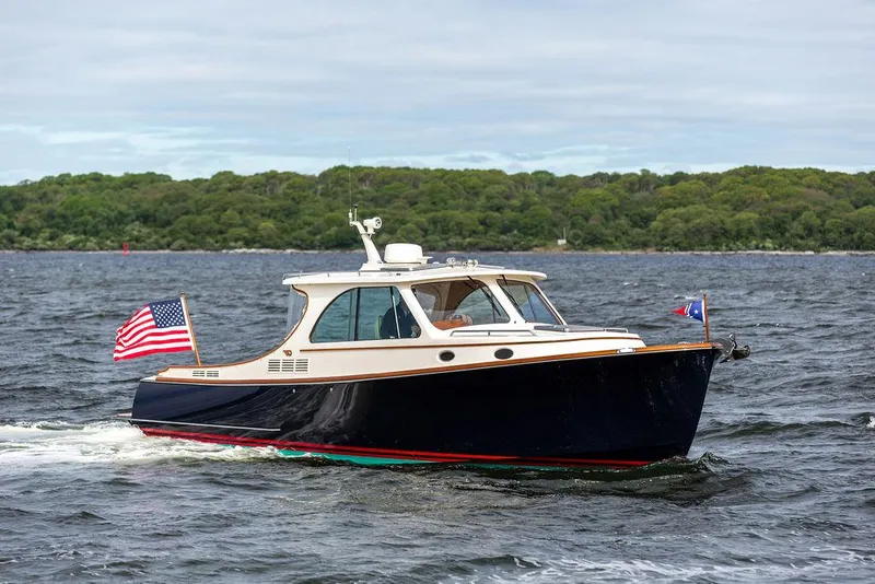 Slide: The Image of 2023 Hinckley Picnic Boat 34 S cruising on a lake with American flag. - 22
