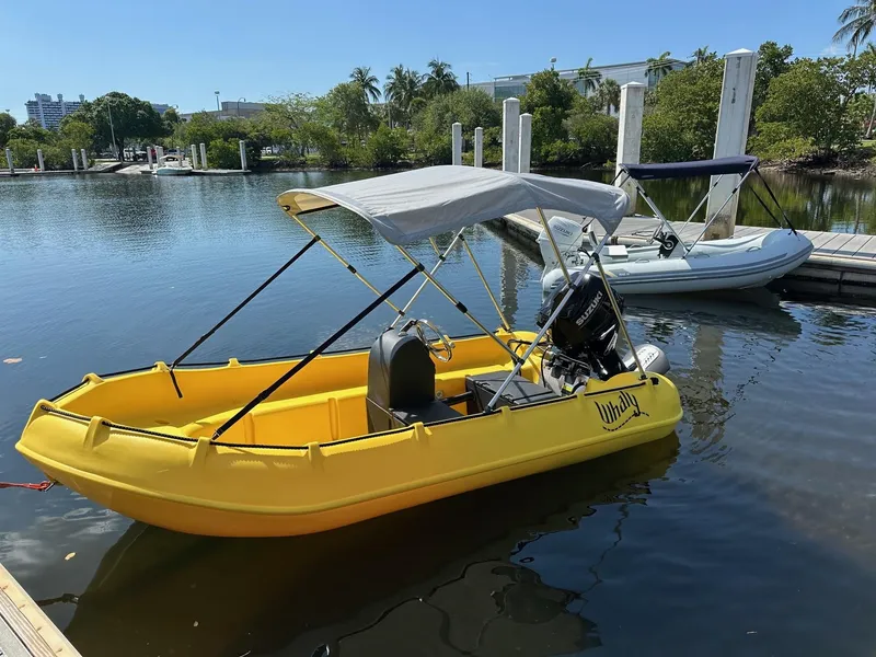 Slide: The Image of Yellow 2025 Whaly 370 Console boat docked on a sunny day. - 2