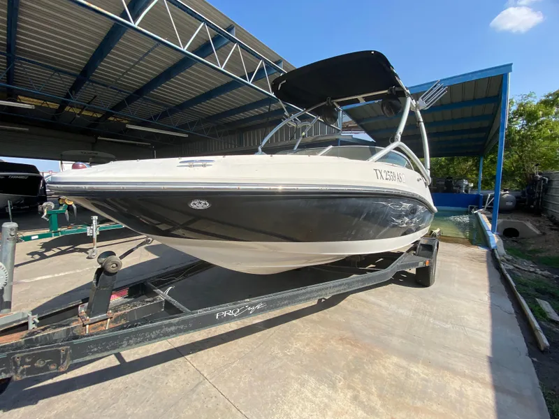 Slide: The Image of 2008 Sea Ray 185 Sport boat on trailer under metal canopy. - 1