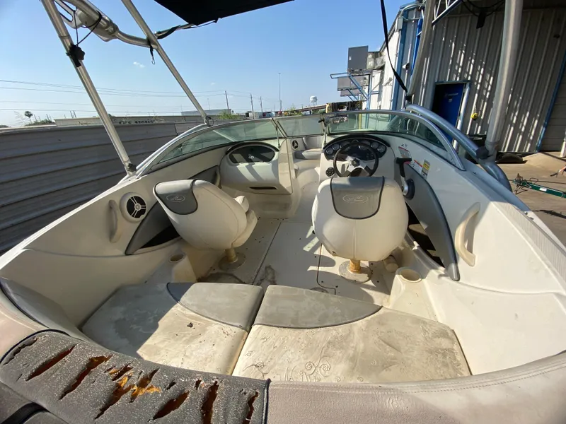 Slide: The Image of 2008 Sea Ray 185 Sport boat interior with seating and steering wheel, docked outdoors. - 5
