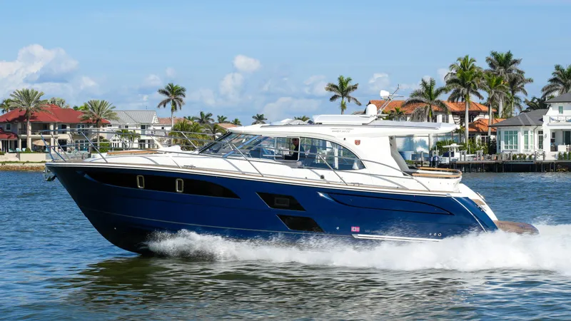The Image of 2025 Marex 360 Cabriolet Cruiser sailing on a sunny day near waterfront homes. - 0