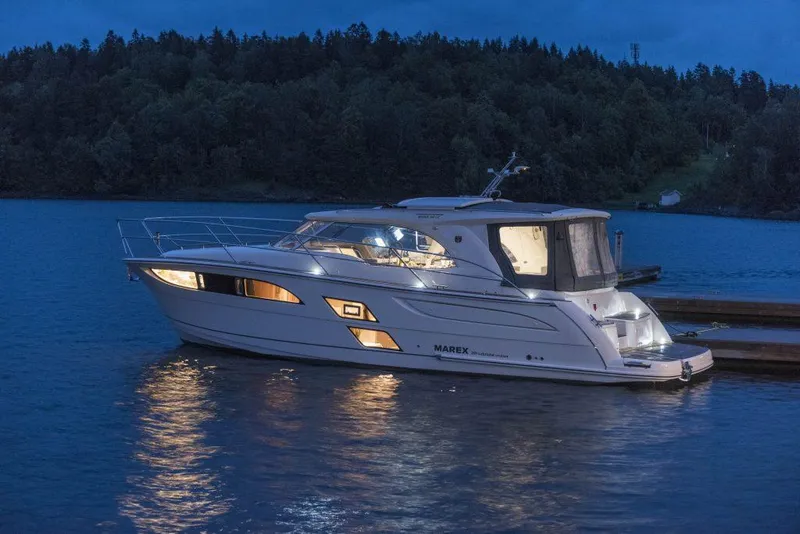 Slide: The Image of 2025 Marex 360 Cabriolet Cruiser docked at night on a serene lake. - 11