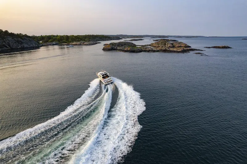 Slide: The Image of 2025 Marex 360 Cabriolet Cruiser navigating scenic coastal waters at sunset. - 13