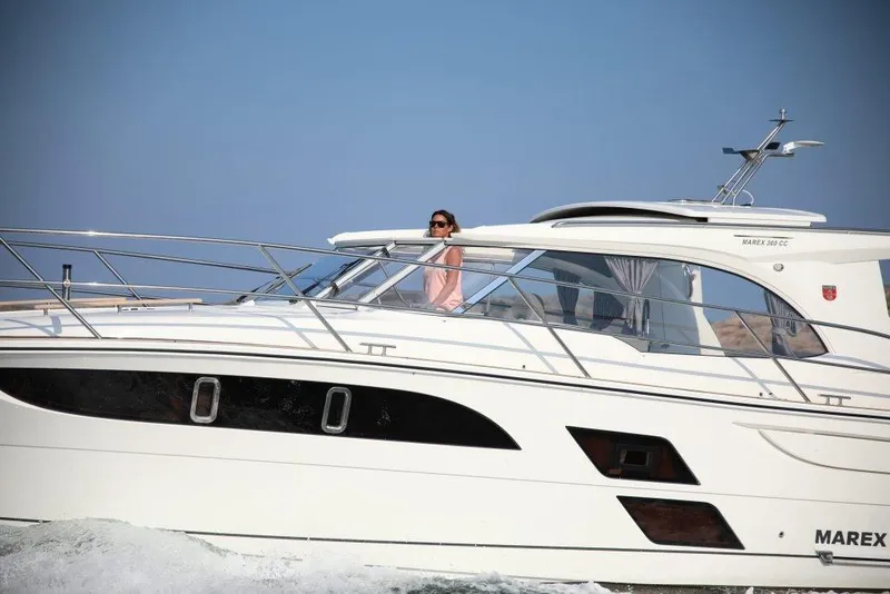 Slide: The Image of 2025 Marex 360 Cabriolet Cruiser sailing on open water, side view. - 15