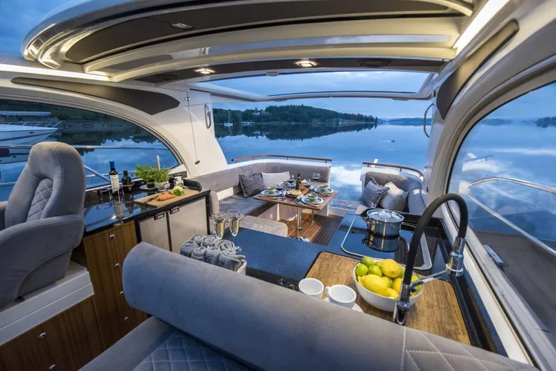 Slide: The Image of Luxurious 2025 Marex 360 Cabriolet Cruiser interior with elegant dining setup and scenic water view. - 23