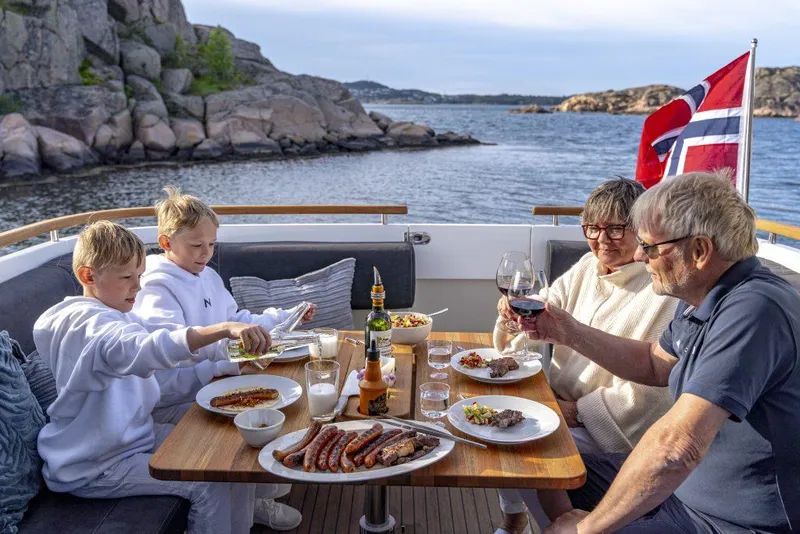 Slide: The Image of Family dining on Marex 360 Cabriolet Cruiser, enjoying a meal with scenic coastal views. - 24