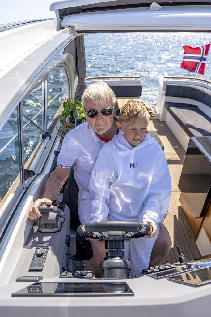 Slide: The Image of Man and child steering 2025 Marex 360 Cabriolet Cruiser on open water. - 28