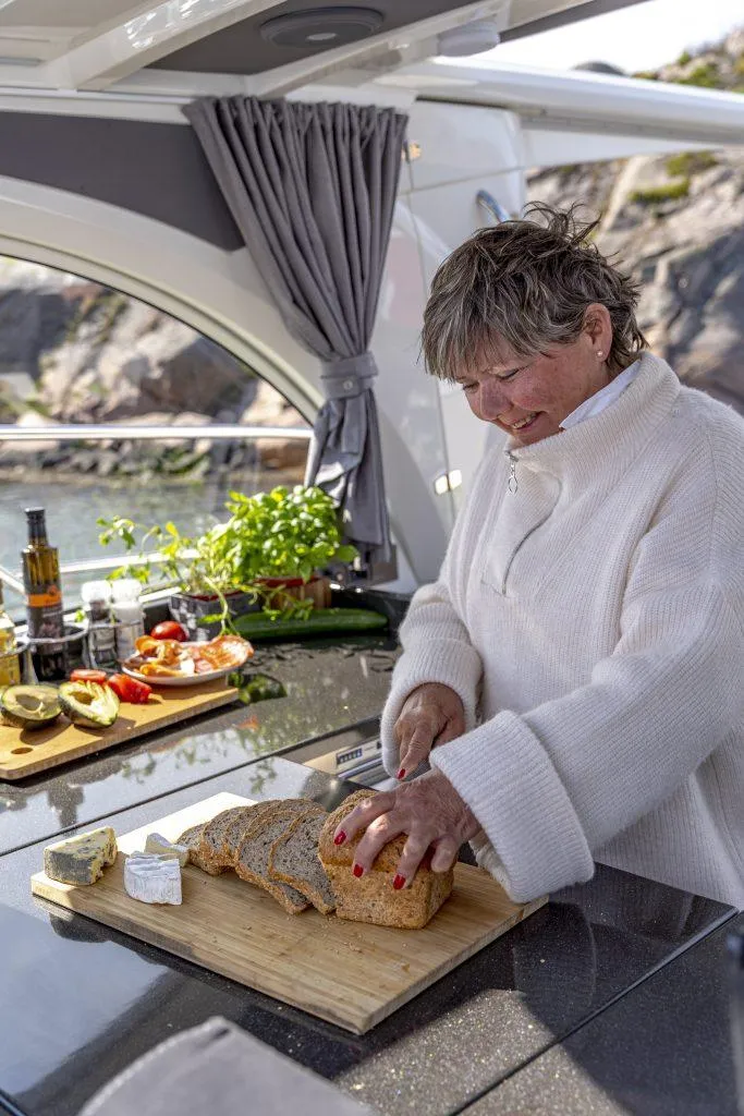 Slide: The Image of Woman slicing bread on Marex 360 Cabriolet Cruiser, 2025 model, with scenic background. - 30