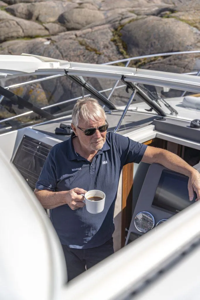 Slide: The Image of Man enjoying coffee on 2025 Marex 360 Cabriolet Cruiser yacht, rocky background. - 32
