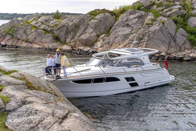 Slide: The Image of 2025 Marex 360 Cabriolet Cruiser navigating rocky coastal waters. - 33