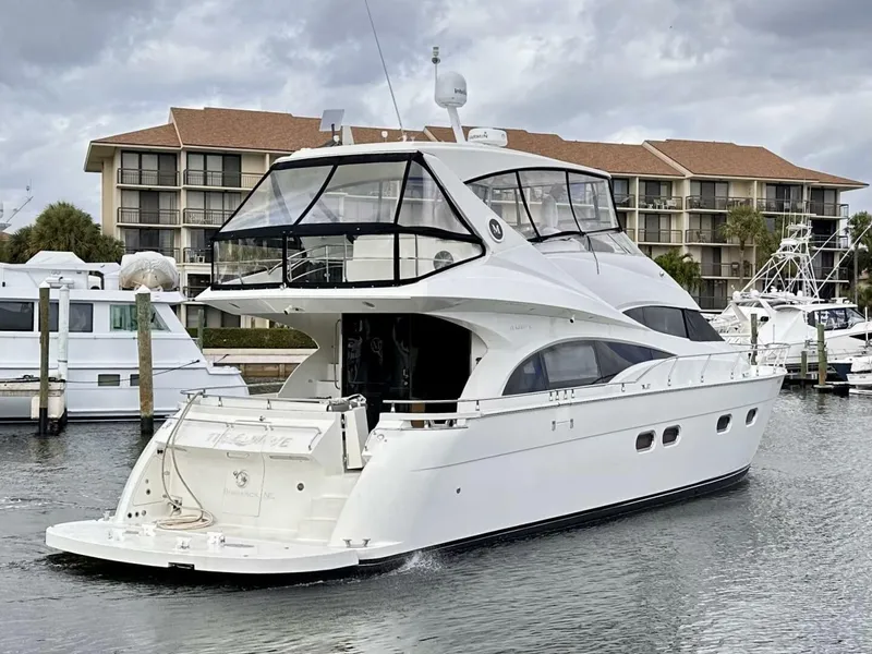 Slide: The Image of 2006 Marquis Flybridge Motor Yacht docked in marina, with modern design and spacious deck. - 2