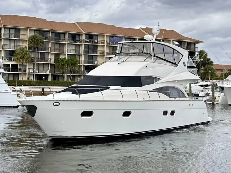 Slide: The Image of 2006 Marquis Flybridge Motor Yacht docked near waterfront apartments. - 3