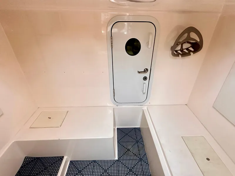 Slide: The Image of Interior of a 2006 Marquis Flybridge Motor Yacht with a white door and seating area. - 30