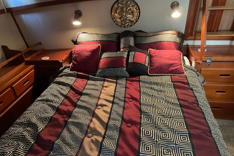 Slide: The Image of Cozy cabin interior of 1991 Grand Banks 46 Motoryacht with red bedding and wooden cabinetry. - 21