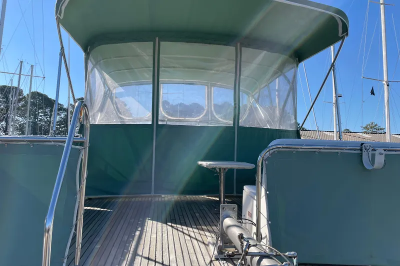 Slide: The Image of 1991 Grand Banks 46 Motoryacht with green cushions and enclosed flybridge, docked outdoors. - 3