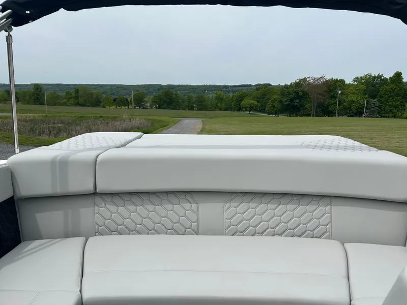 Slide: The Image of 2025 Four Winns H2 Freedom boat interior with white cushioned seating and scenic background. - 11