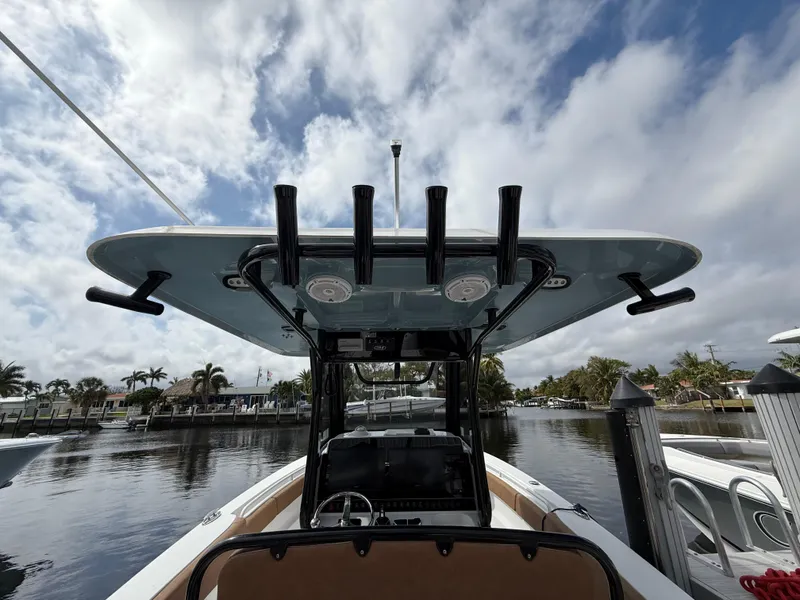 Slide: The Image of 2023 Sea Hunt Gamefish 30 boat with forward seating, docked under a cloudy sky. - 13
