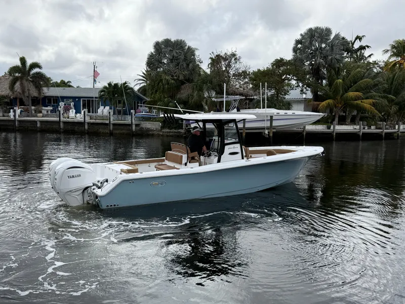 Slide: The Image of 2023 Sea Hunt Gamefish 30 boat with forward seating on a calm waterway. - 27