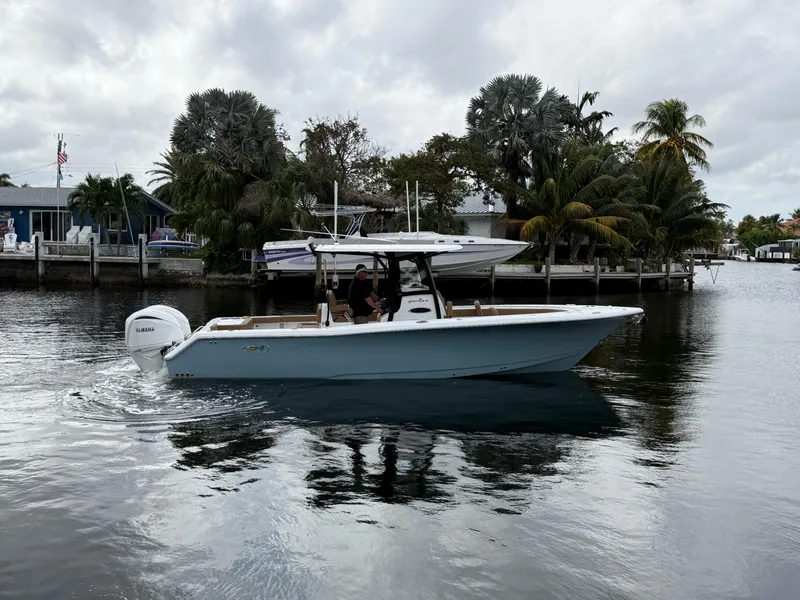 Slide: The Image of 2023 Sea Hunt Gamefish 30 boat cruising on a calm waterway near palm trees. - 28