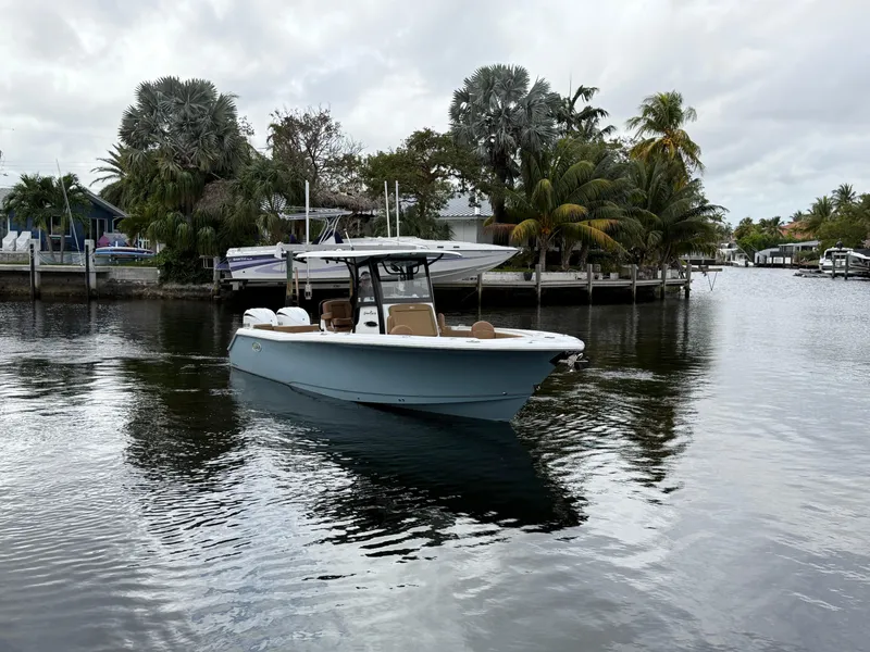 Slide: The Image of 2023 Sea Hunt Gamefish 30 boat on a calm waterway, surrounded by lush greenery. - 30