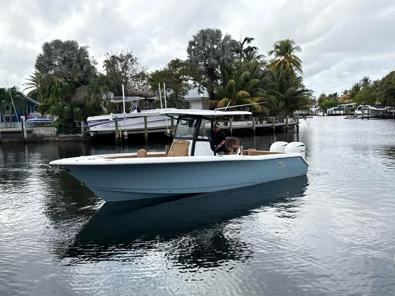 Slide: The Image of 2023 Sea Hunt Gamefish 30 boat on a calm waterway, surrounded by lush greenery. - 33