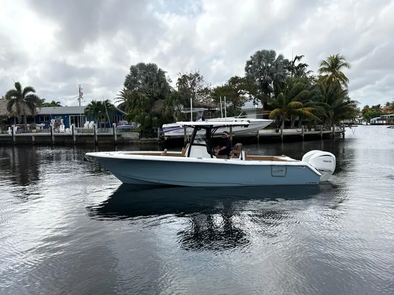 Slide: The Image of 2023 Sea Hunt Gamefish 30 boat on calm water near a tropical shoreline. - 35