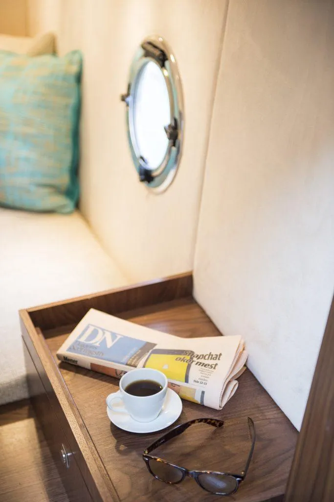 Slide: The Image of Cozy Marex 375 cabin interior with coffee, newspaper, and porthole, 2025 model. - 25