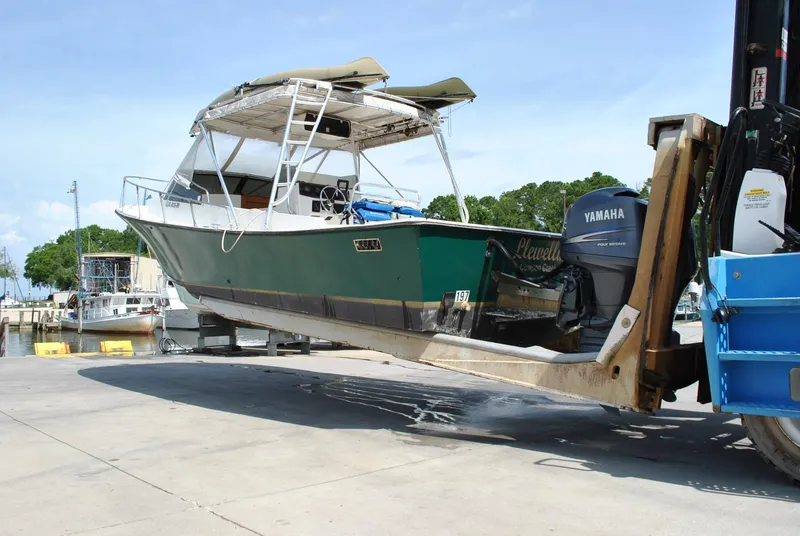 Slide: The Image of 1987 Halter 31 Lafitte Skiff boat lifted by forklift, featuring Yamaha outboard motor. - 10