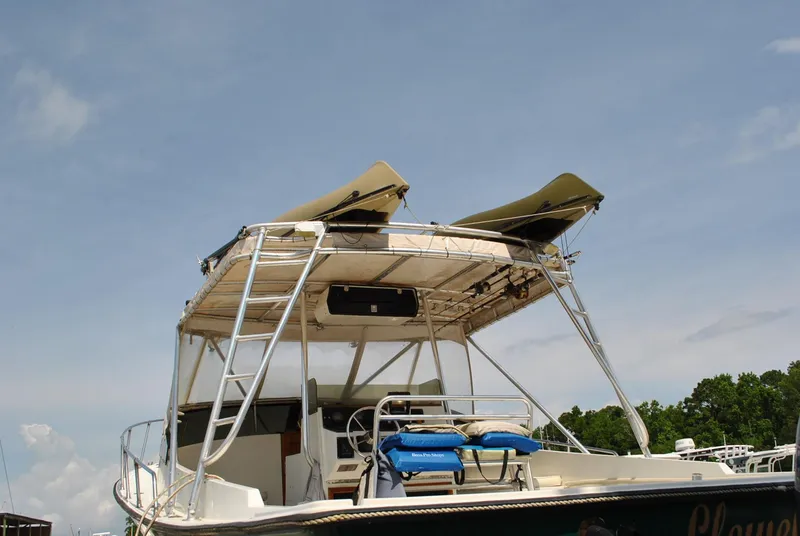 Slide: The Image of 1987 Halter 31 Lafitte Skiff with canopy and seating, docked under a clear sky. - 15