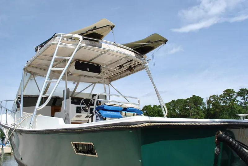 Slide: The Image of 1987 Halter 31 Lafitte Skiff boat with canopy, docked under clear sky. - 16