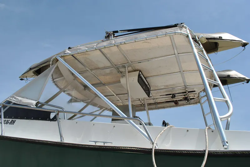 Slide: The Image of 1987 Halter 31 Lafitte Skiff boat with canopy and railing, viewed from the side. - 17