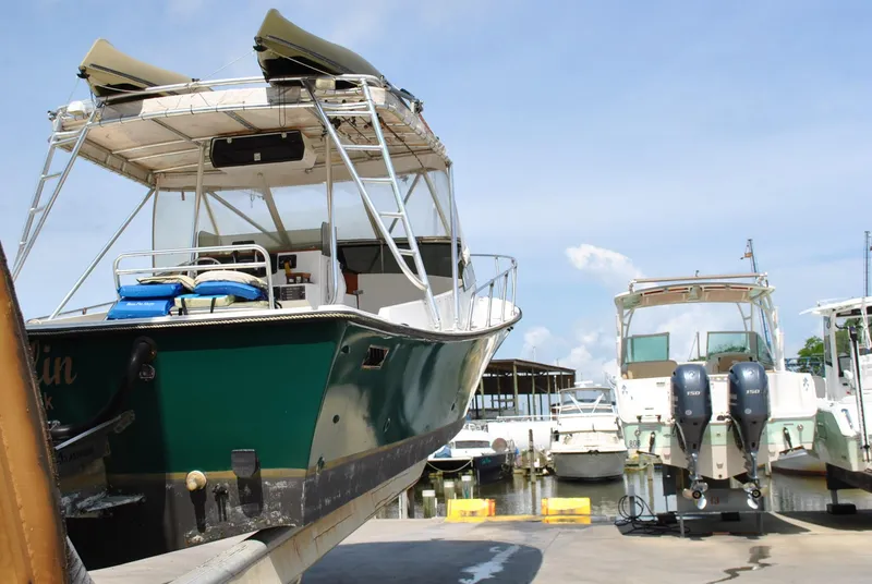 Slide: The Image of 1987 Halter 31 Lafitte Skiff boat docked at marina, clear sky background. - 18