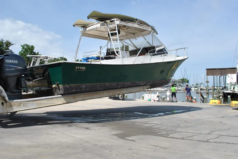 Slide: The Image of 1987 Halter 31 Lafitte Skiff boat on trailer at marina, Yamaha engines visible. - 19