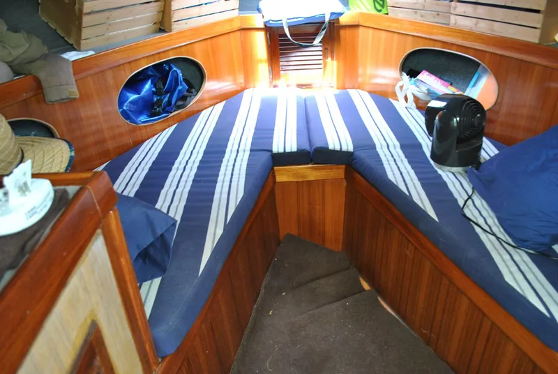 Slide: The Image of 1987 Halter 31 Lafitte Skiff interior with striped cushions and wooden paneling. - 26