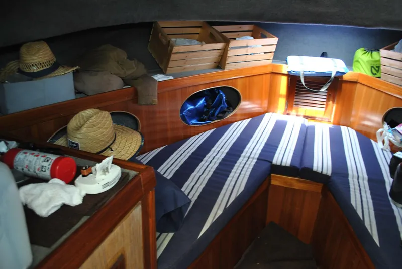Slide: The Image of Cozy cabin interior of 1987 Halter 31 Lafitte Skiff with striped bedding and wooden storage. - 28