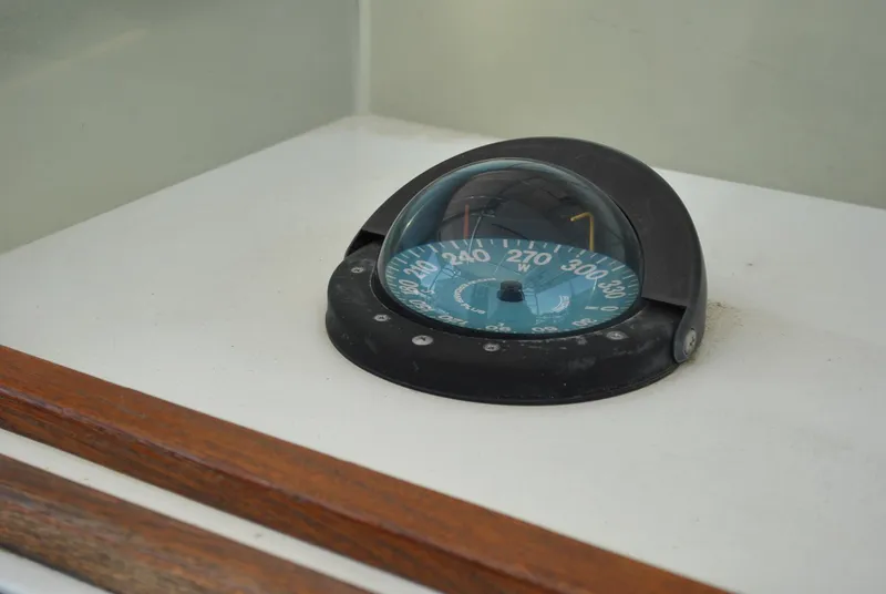 Slide: The Image of Compass on 1987 Halter 31 Lafitte Skiff boat dashboard. - 32