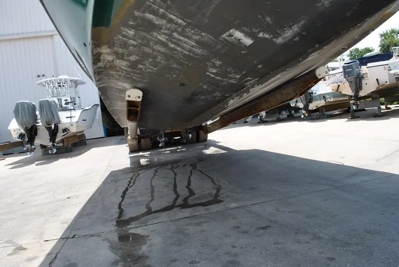 Slide: The Image of 1987 Halter 31 Lafitte Skiff boat hull on dry dock, showing underside and water drips. - 36