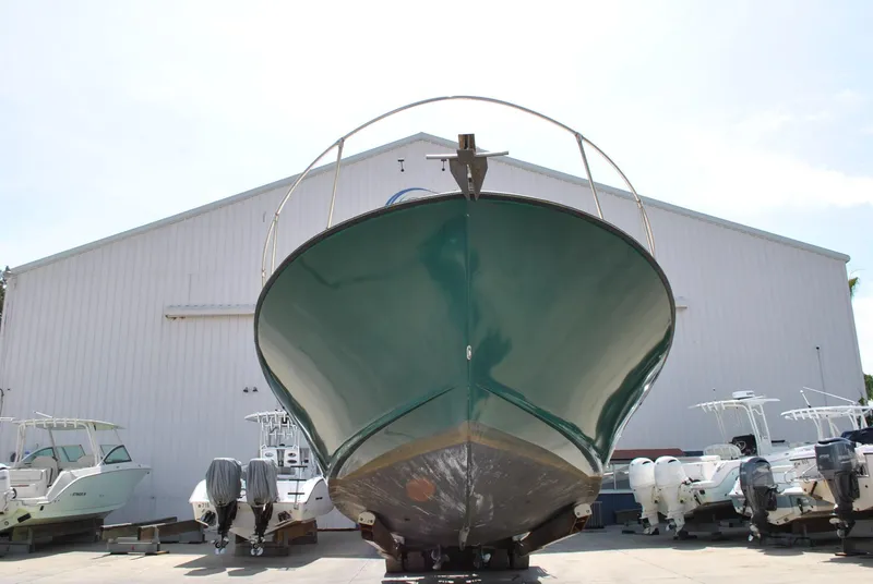 Slide: The Image of 1987 Halter 31 Lafitte Skiff boat on display in front of a large warehouse. - 8