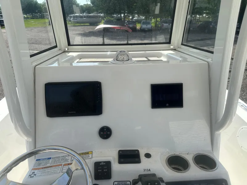Slide: The Image of 2023 NauticStar 2602 Legacy boat dashboard with navigation screens and controls. - 16