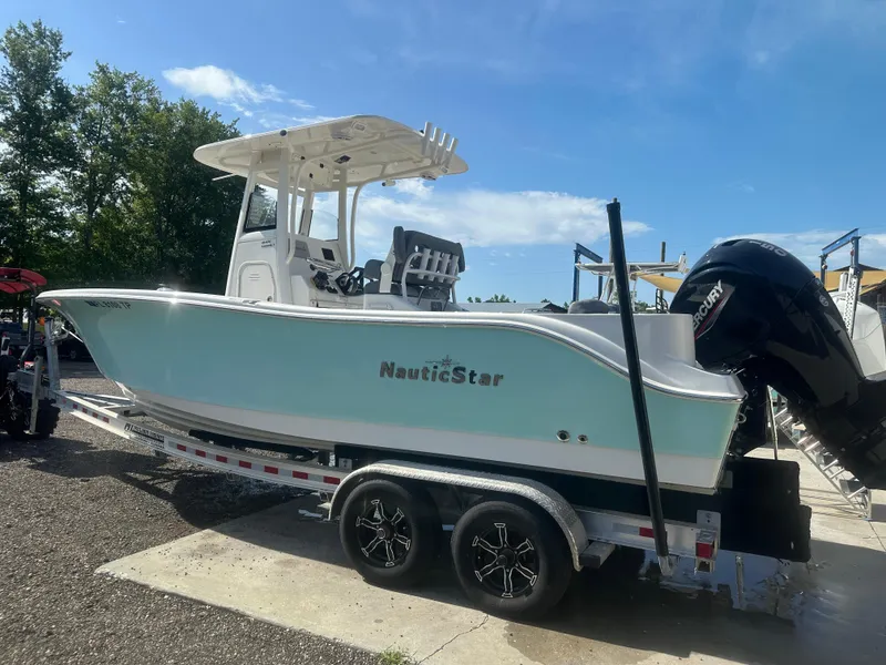 Slide: The Image of 2023 NauticStar 2602 Legacy boat on trailer, blue hull, sunny day. - 3