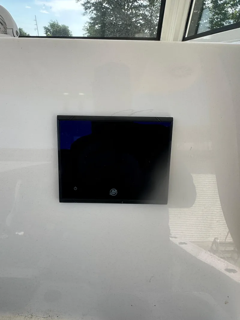 Slide: The Image of 2023 NauticStar 2602 Legacy boat dashboard with a digital display screen. - 31