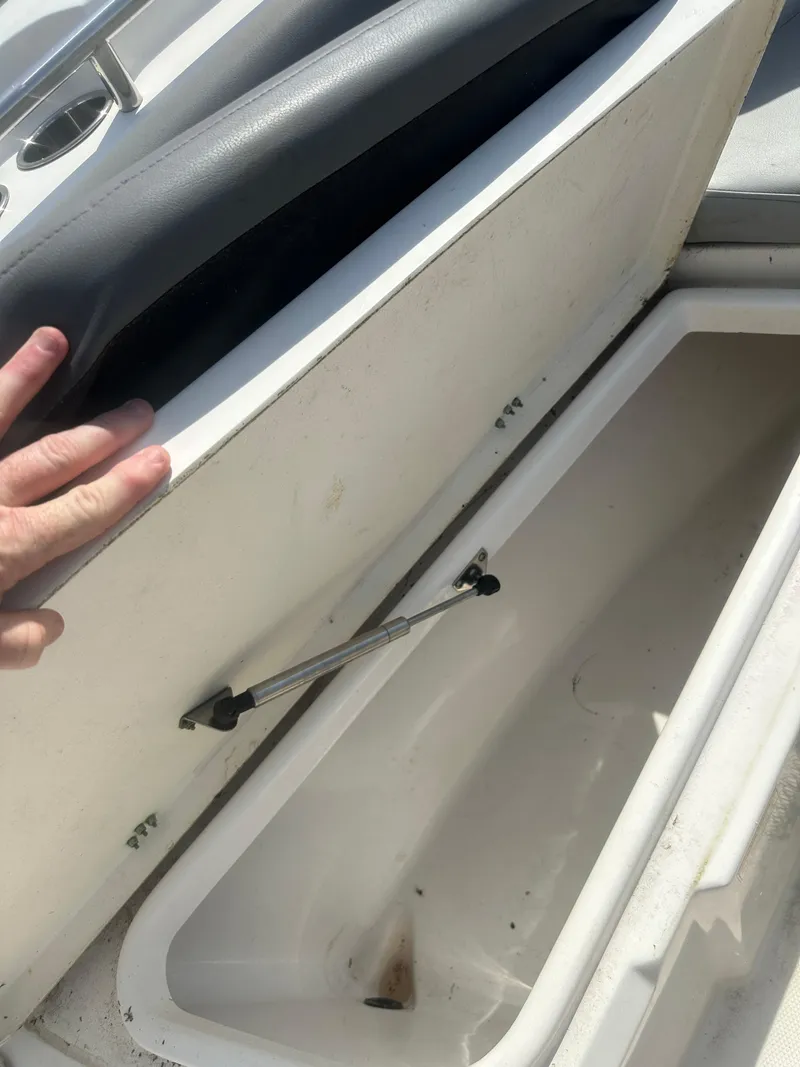 Slide: The Image of 2023 NauticStar 2602 Legacy boat storage compartment with open lid. - 34