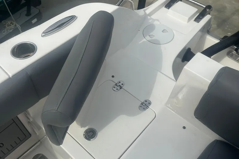 Slide: The Image of 2023 NauticStar 2602 Legacy boat interior with gray seating and cup holder. - 38