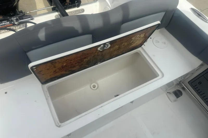Slide: The Image of 2023 NauticStar 2602 Legacy boat with open storage compartment and cushioned seating. - 45