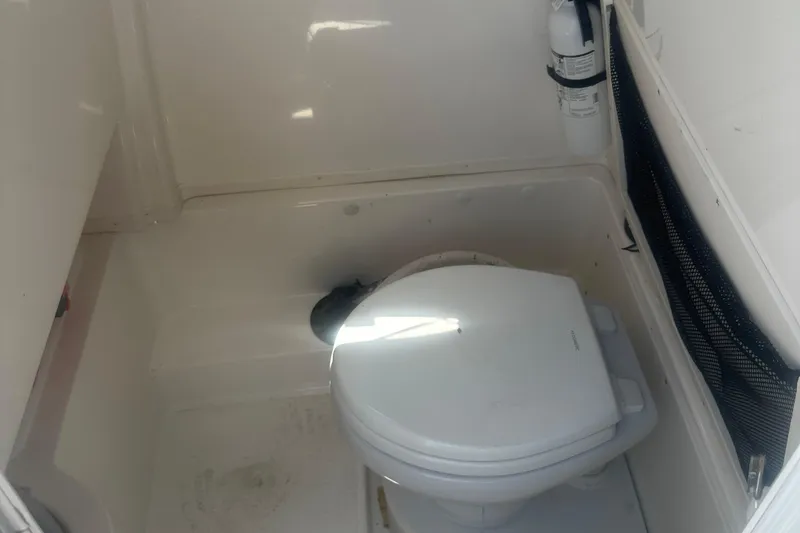 Slide: The Image of 2023 NauticStar 2602 Legacy boat interior with toilet and fire extinguisher. - 46
